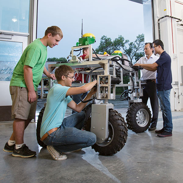 students working with field robot in large work bay