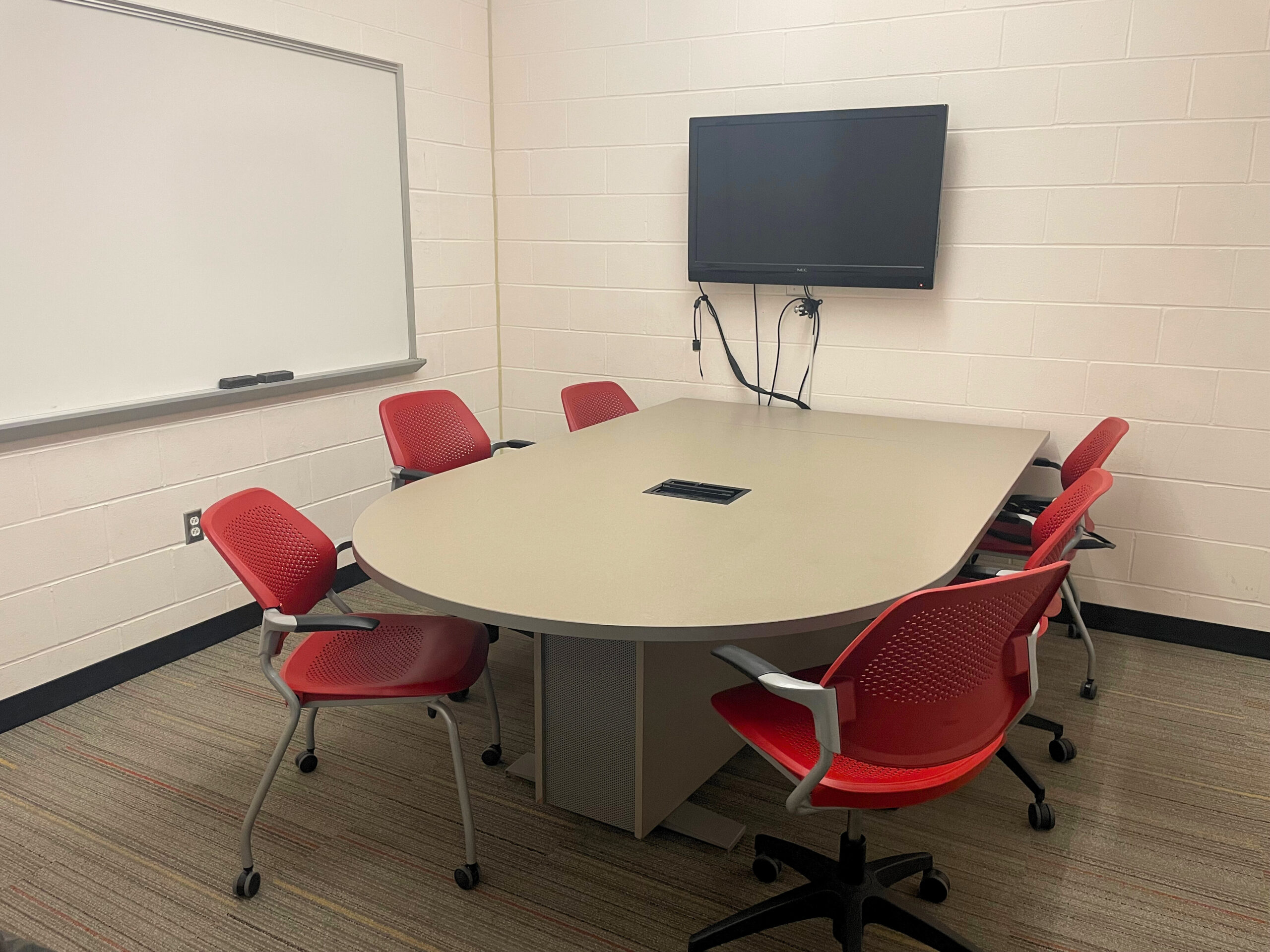 Conference room with display and 6 chairs.